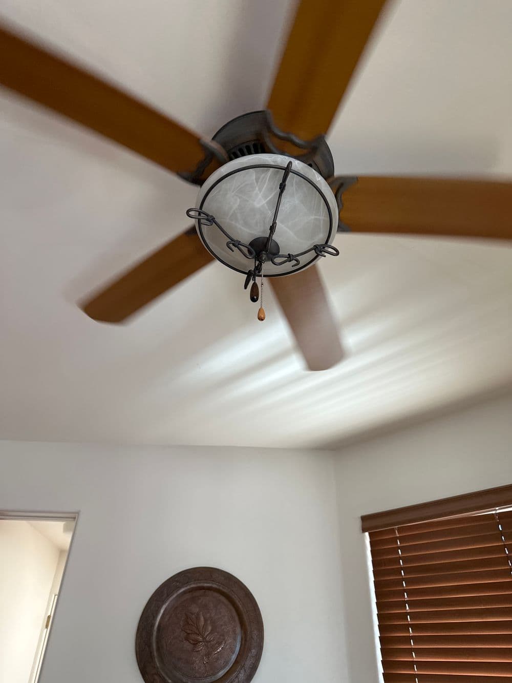 ceiling fan with wooden blades and decorative light fixture in a modern room